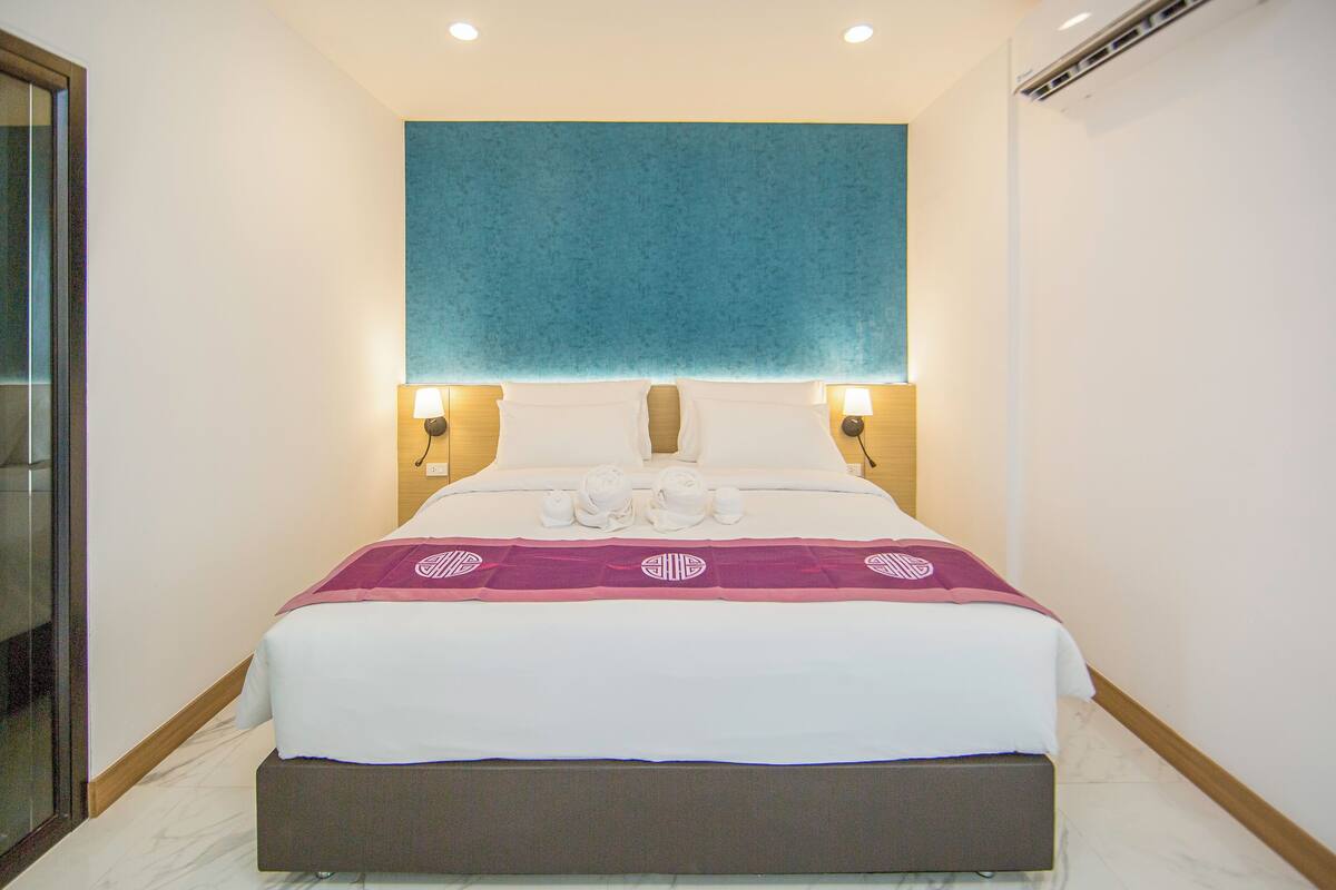 Ein Hotelzimmer mit einem großen Bett, zwei Nachttischlampen und einer blauen Wand.