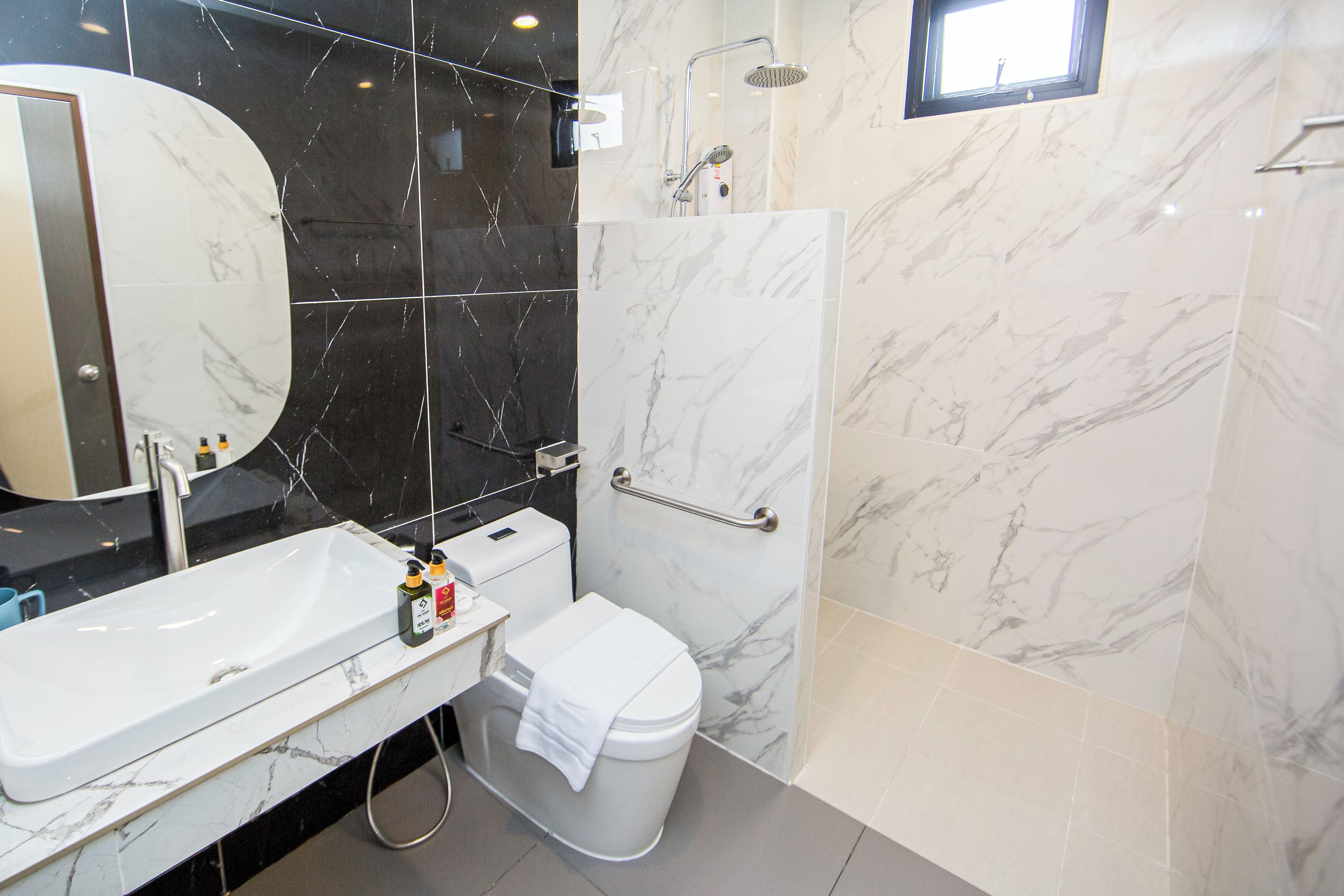 A bathroom with a white sink, toilet, and shower.