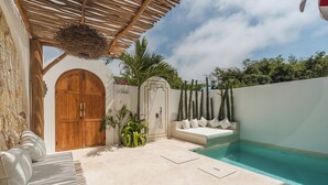A pool area with a wooden door, a white wall, and a cactus garden. - Villa Mauka by Alfred in Bali (Canggu)