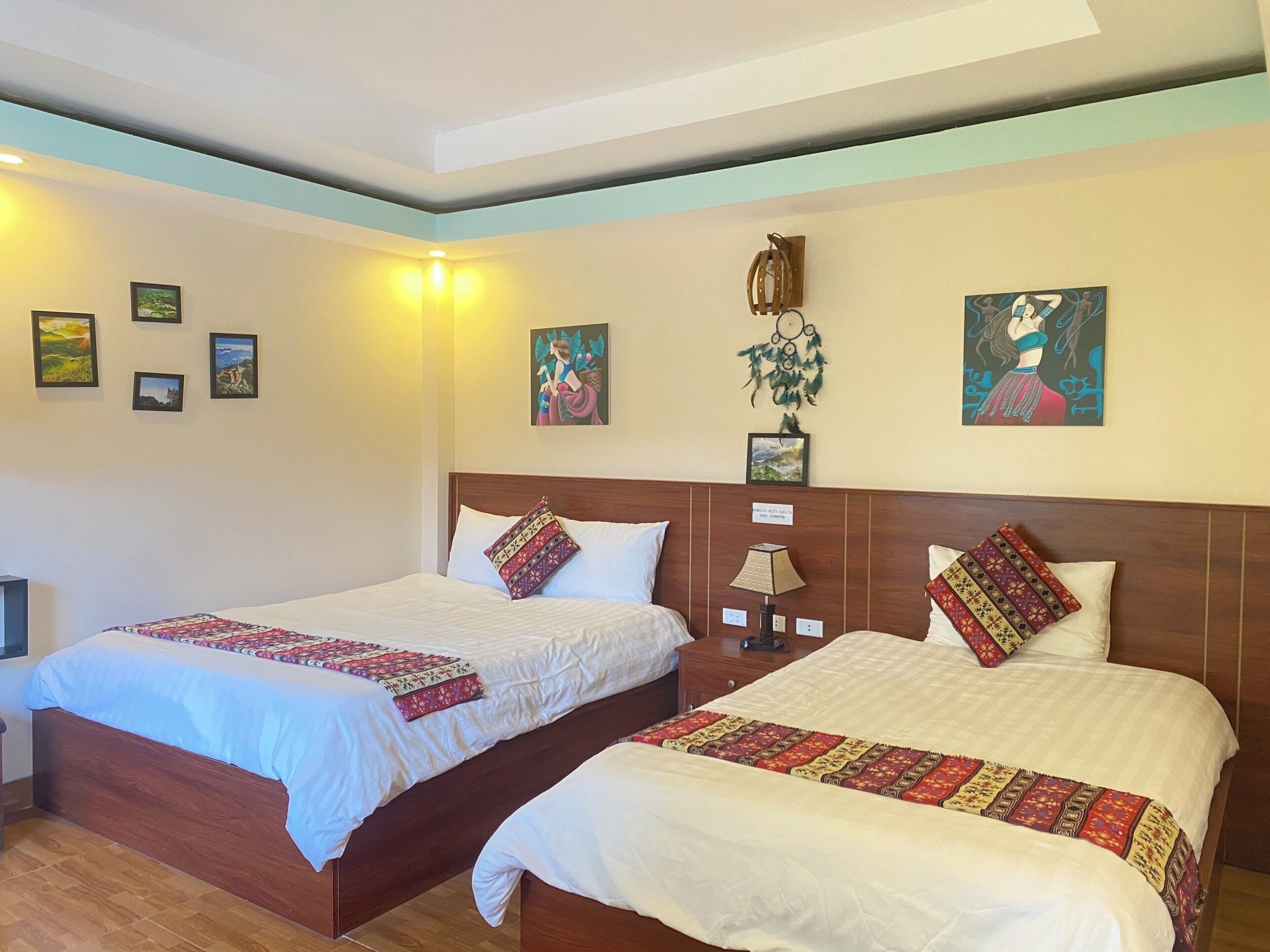 A hotel room with two beds, wooden headboards, and a ceiling with recessed lighting.