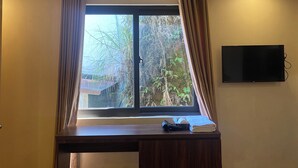 A room with a window, a desk, and a flat-screen TV mounted on the wall. - Misty Hostel Sapa (Sa Pa)