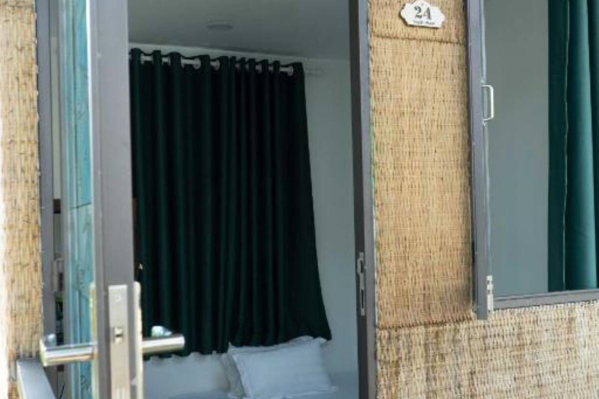 Ein Zimmer mit einem Bett, grünen Vorhängen und einem Schild mit einer Nummer an der Wand.