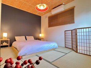 A hotel room with a bed, bedside lamps, an air conditioner, and a shoji screen. - LA FELICE (Otaru)