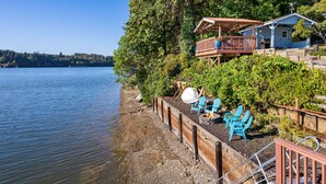 A lakeside cabin with a deck, outdoor seating, and a view of the lake. - Captain s Retreat in Shelton (Shelton)