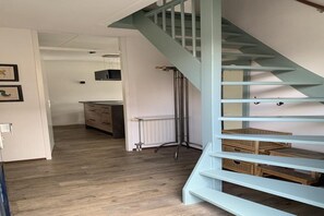 Stunning interior with a staircase, kitchen area, and framed pictures on the wall.