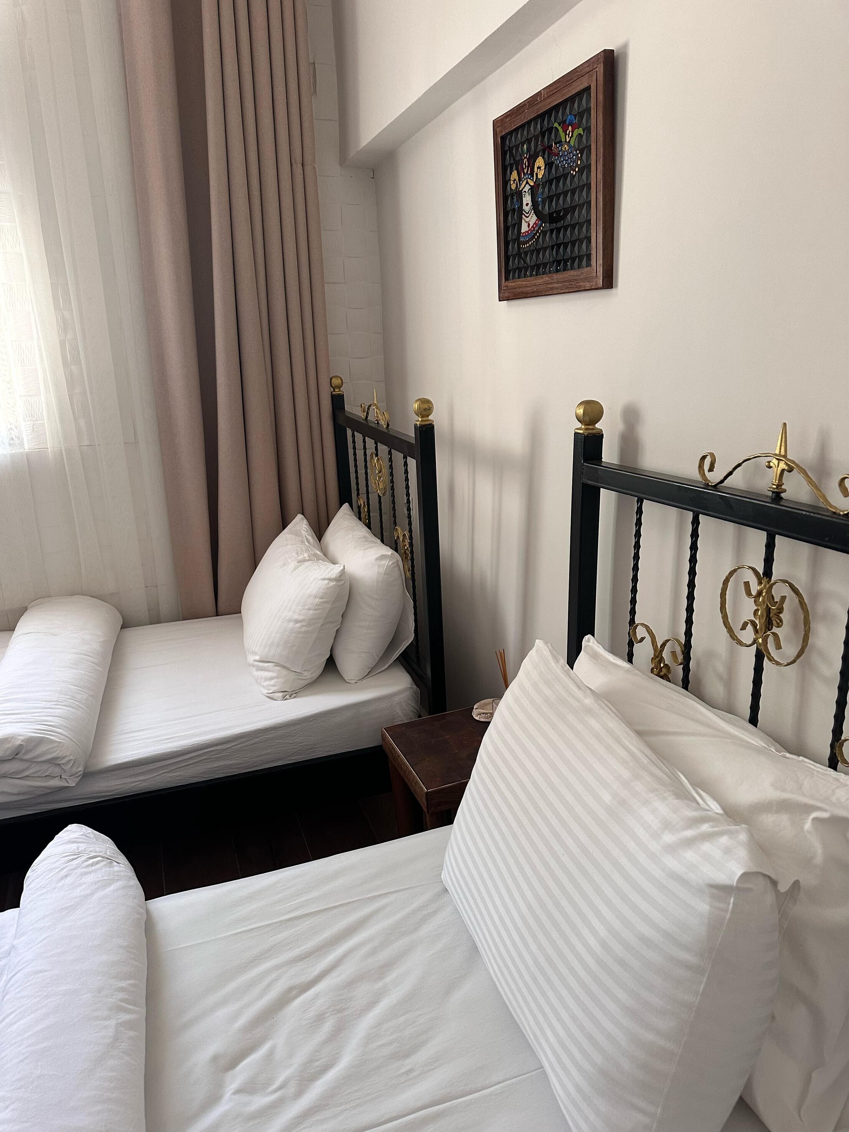 A bedroom with a bed, a nightstand, and a framed picture on the wall.