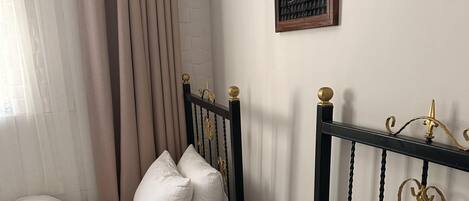 A bedroom with a bed, a nightstand, and a framed picture on the wall.