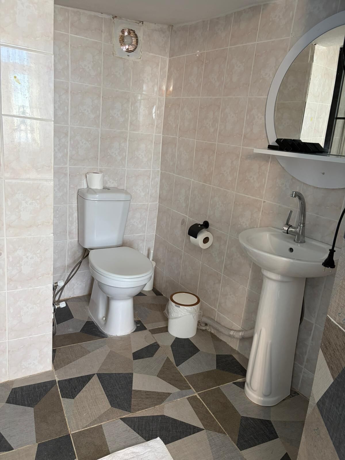 Un baño con inodoro, lavamanos y ducha.