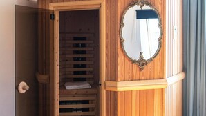 Um armário de madeira com espelho, uma mesa de madeira com livros e um banco de madeira.
