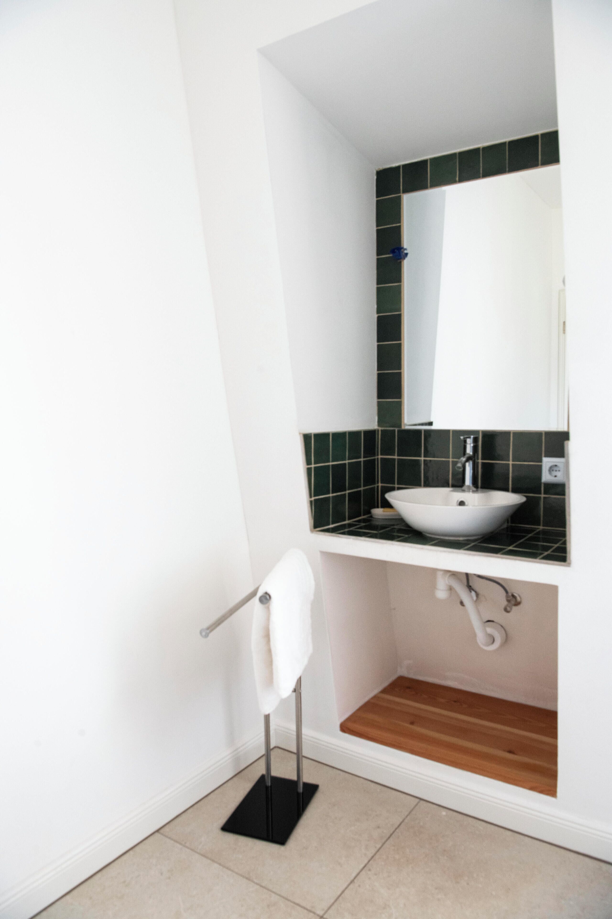 Ein Badezimmer mit Waschbecken, Spiegel und Handtuchhalter.