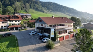 A building with a red roof, a sign reading "Alte Post," and a parking lot with several cars.