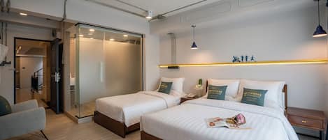 Ett hotellrum med två sängar, en sittgrupp, ett skrivbord och en garderob.