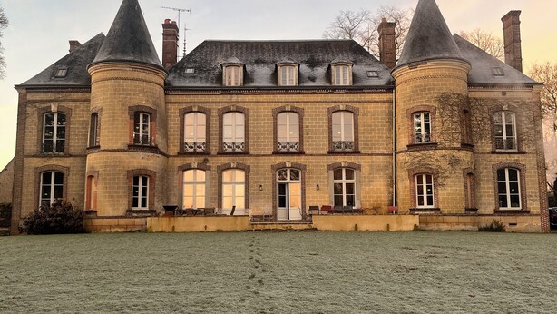 Een groot, historisch gebouw met meerdere torens en een ruime binnenplaats.