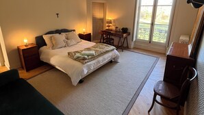 Een slaapkamer met een bed, bureau, stoel en een bank.