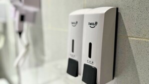 A restroom with two hand sanitizer dispensers mounted on the wall. - Smile Hotel SS2 Petaling Jaya (Petaling Jaya)