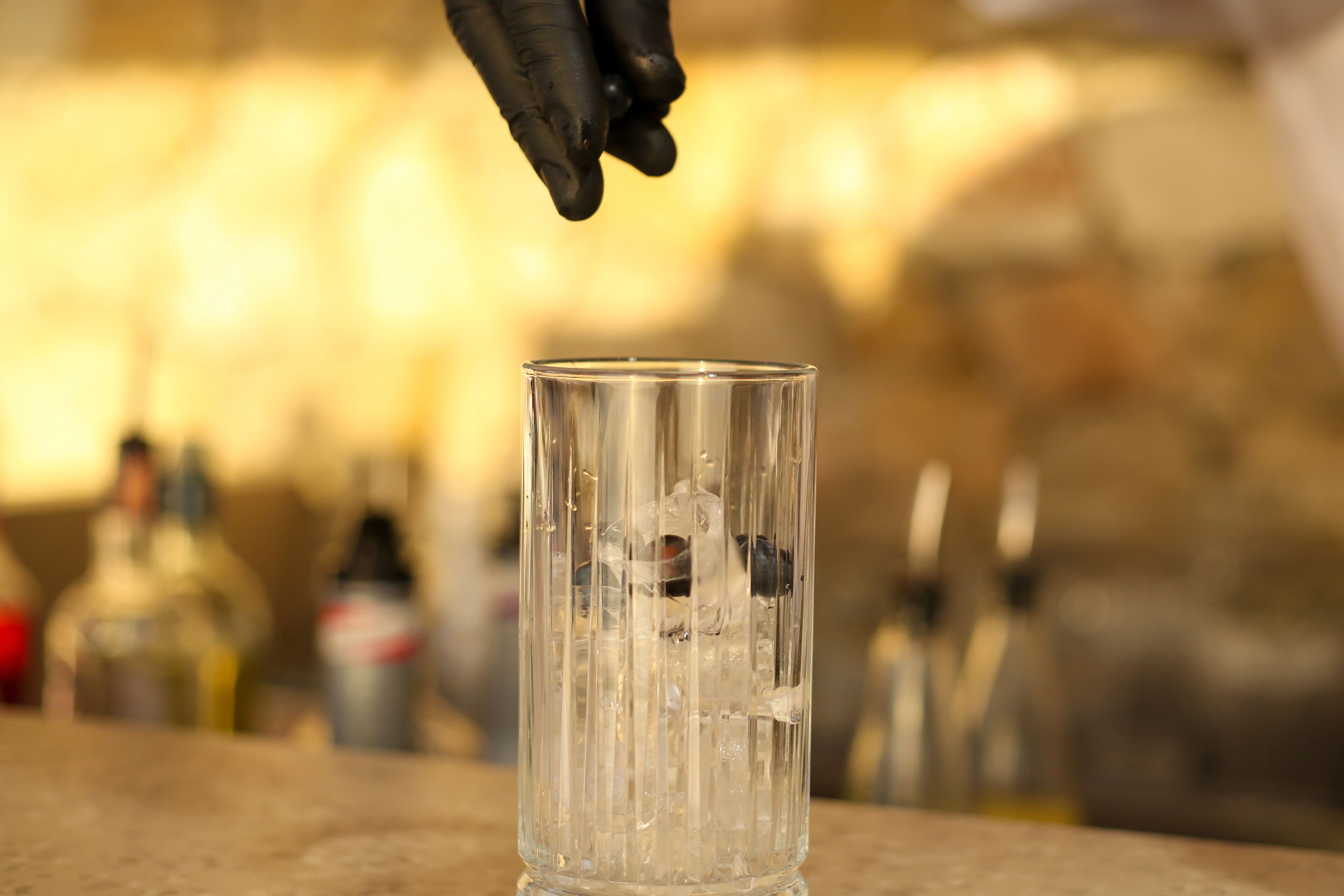 A clear glass with ice cubes on a table.