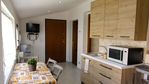 Une cuisine moderne avec des meubles en bois, un four à micro-ondes et un coin repas comprenant une table et des chaises.
