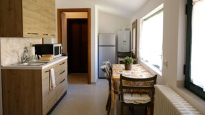 Une cuisine moderne avec des meubles en bois, un four à micro-ondes et un coin repas comprenant une table et des chaises.