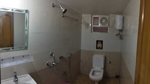 Ein kleines Badezimmer mit Dusche, Toilette und Waschbecken.