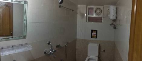 A small bathroom with a shower, toilet, and sink.