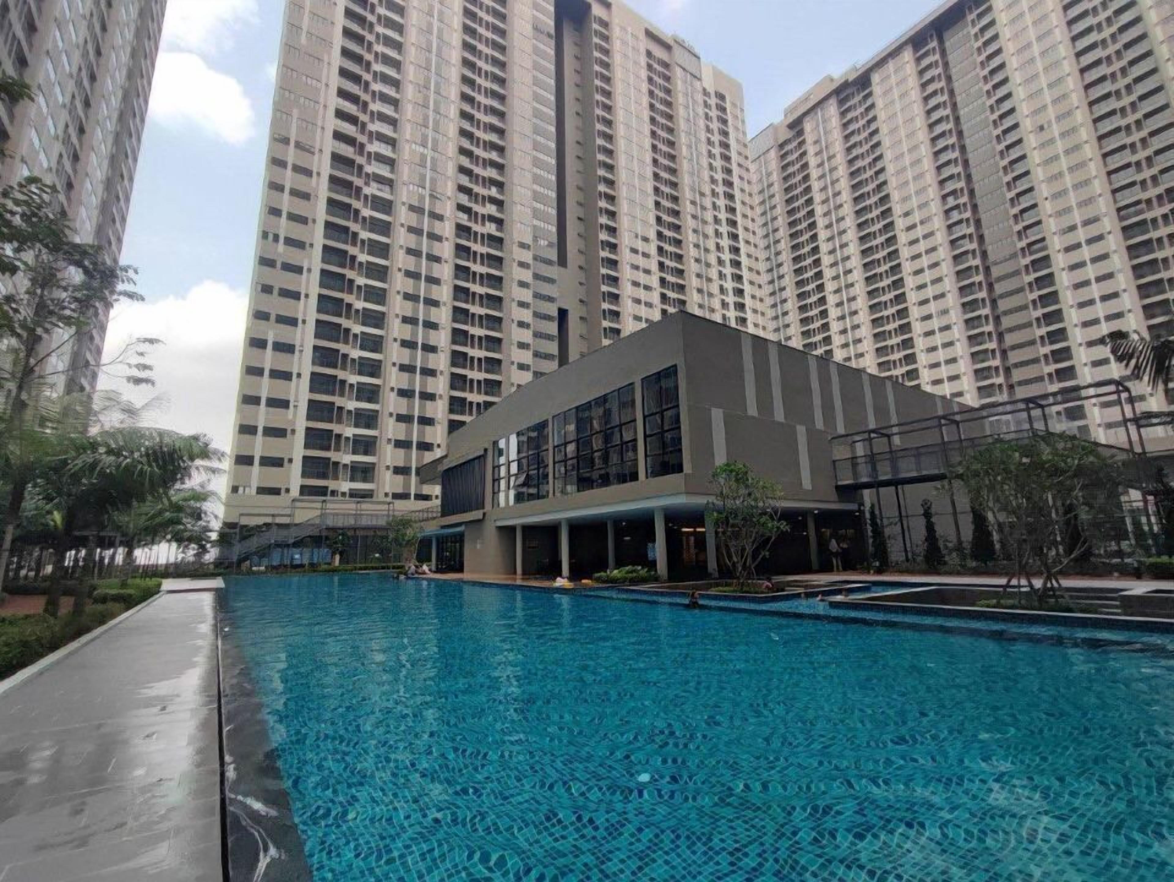 A modern building with a swimming pool in front.