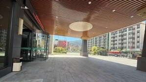 A modern building entrance with a wooden ceiling and glass doors. - Linzhi Hotel (Nyingchi)