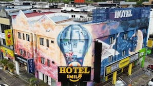 A hotel building with a colorful mural on the facade, a prominent 'HOTEL' sign, and a 'SMILE' logo. - Smile Hotel Shah Alam Seksyen 9 (Shah Alam)