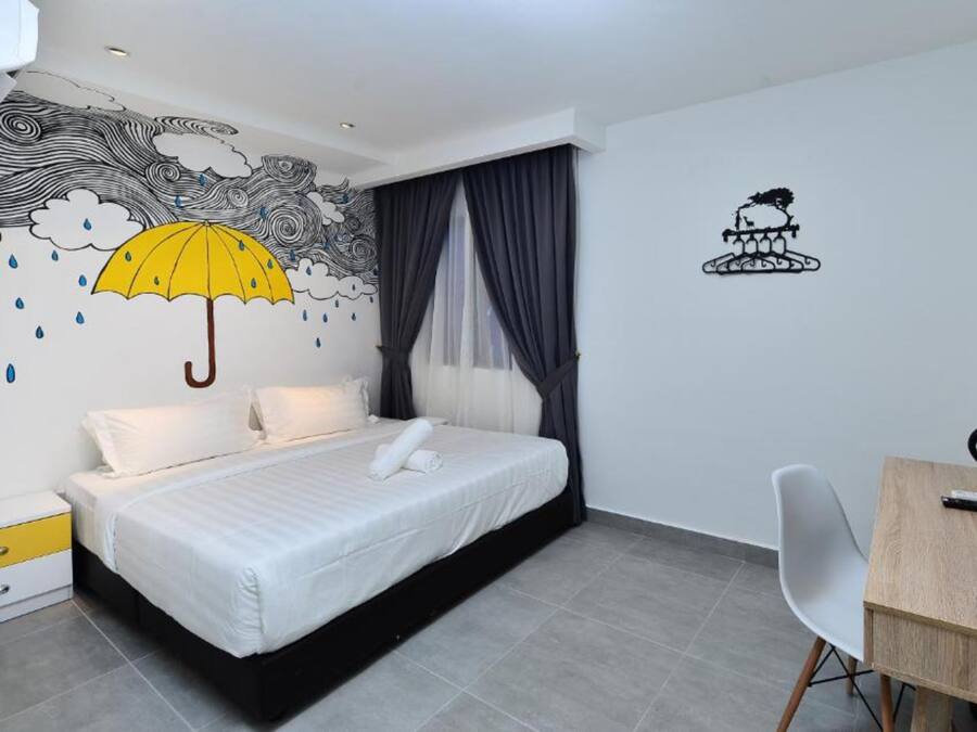 A bedroom with a bed, a desk, and a chair.