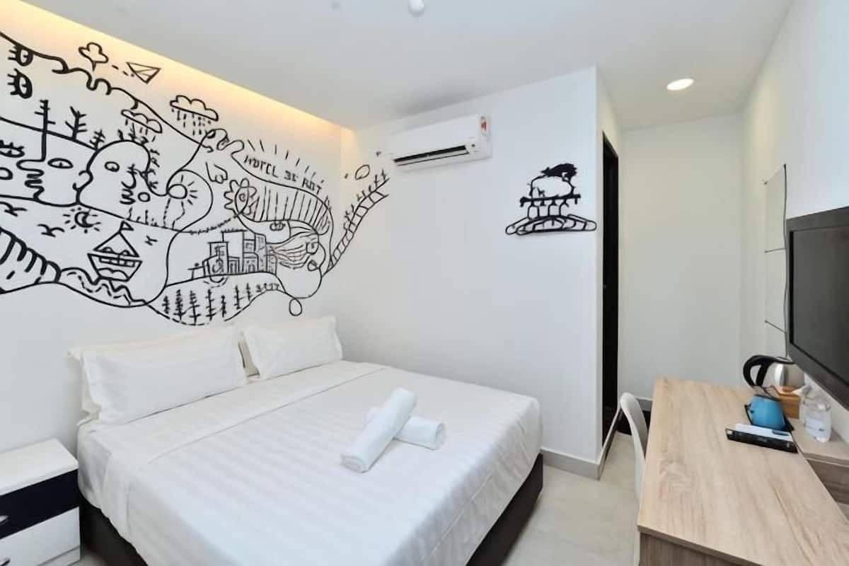 Una habitación de hotel con una cama, un escritorio, un televisor y un mural en la pared.