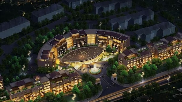 A circular building complex with multiple connected structures, surrounded by greenery and adjacent to a road. - Grand Metropark Qingdao (Qingdao)