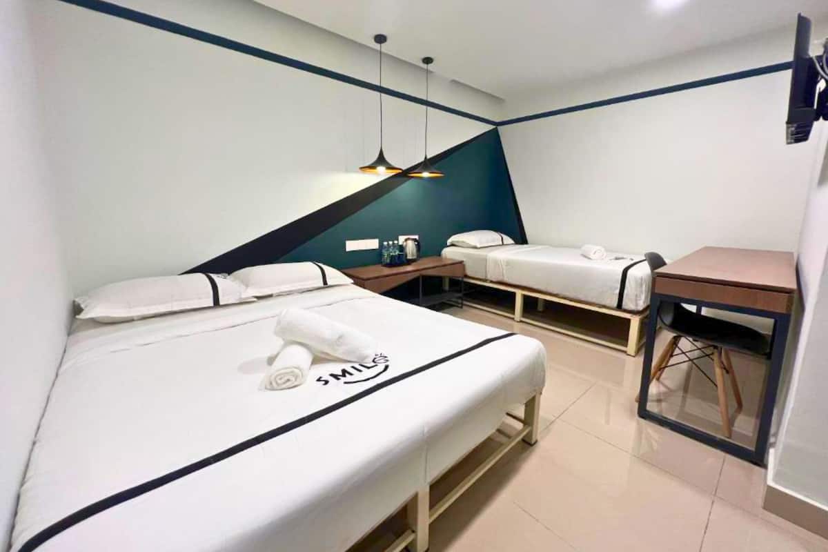 Een hotelkamer met twee bedden, een bureau en een stoel.