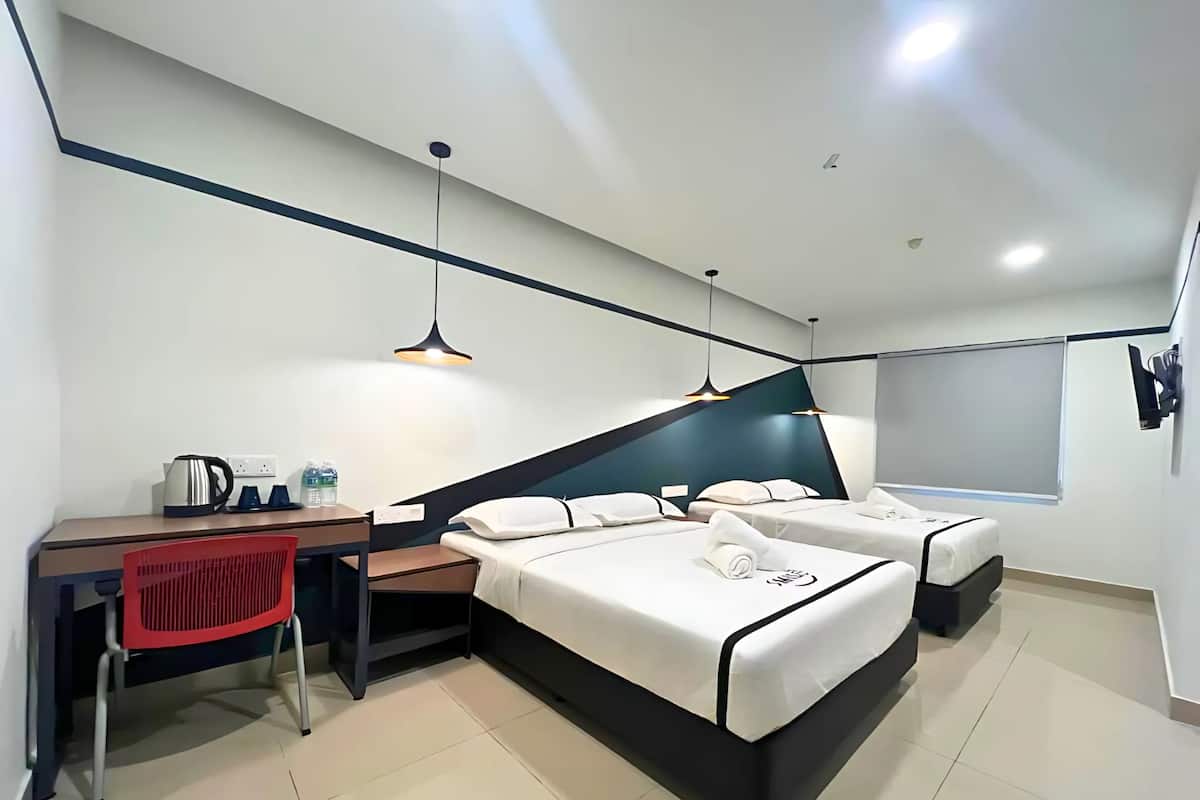 Een moderne hotelkamer met een bureau, twee bedden, een rode stoel en een groot raam.