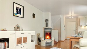 Een moderne woonkamer met een open haard, witte meubels en een gezellig tapijt.