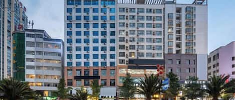 A multi-story hotel with a modern facade, featuring a prominent signage at the top.