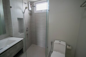 Enjoy a refreshing shower in the sleek bathroom with a glass-enclosed shower and wall-mounted faucet.