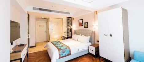 Une chambre d’hôtel équipée d’un lit, d’une armoire, d’une télévision et d’un bureau.
