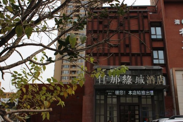Un bâtiment avec une enseigne indiquant « Hôtel de la ville de Zhangjie » et une porte d’entrée.