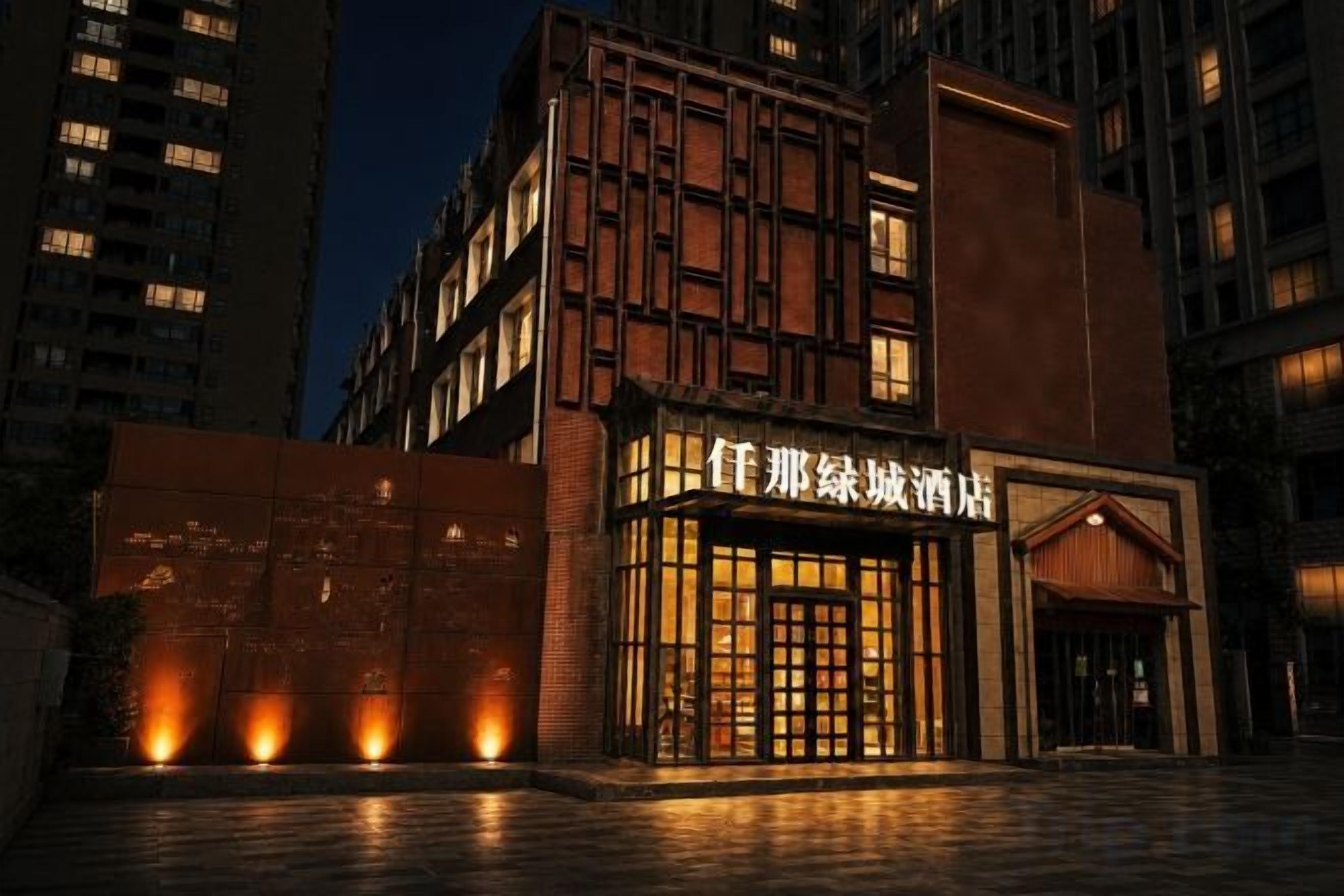 Un hotel con fachada moderna, entrada iluminada y un letrero con caracteres chinos.