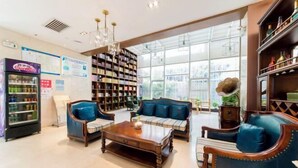 A spacious lobby with a large bookshelf, seating area, and a vending machine.