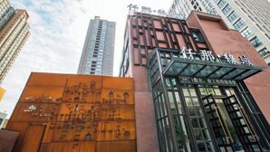 A modern building with a prominent entrance and a large glass facade.