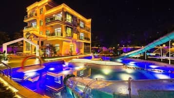 A multi-story hotel with a swimming pool and water slides.