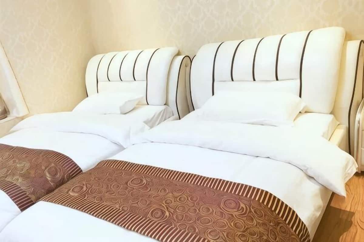 A double bed with a patterned bedspread and a headboard with vertical lines.