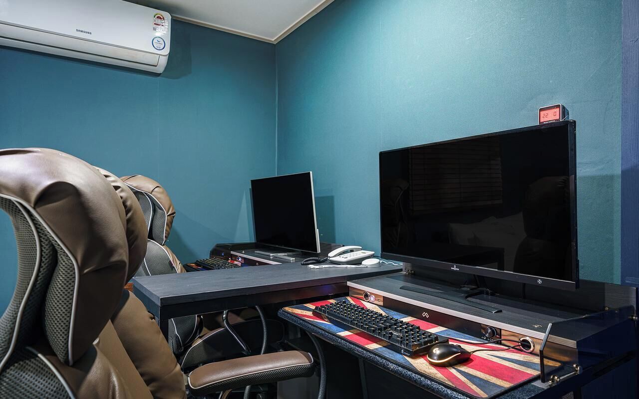A home office setup with a desk, two monitors, a keyboard, a mouse, and a leather chair.