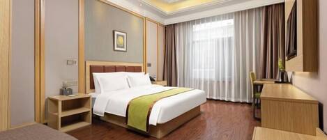 A hotel room with a bed, bedside table, chair, desk, and a large window with curtains.