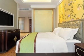 A hotel room with a bed, a television, a wooden dresser, and a window with blinds. - Baroque Hotel Harbin China Baroque (Harbin)