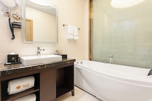 A bathroom with a white bathtub, a sink, a mirror, and a towel rack. - Baroque Hotel Harbin China Baroque (Harbin)
