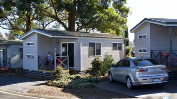 A single-story mobile home with a car parked in front.