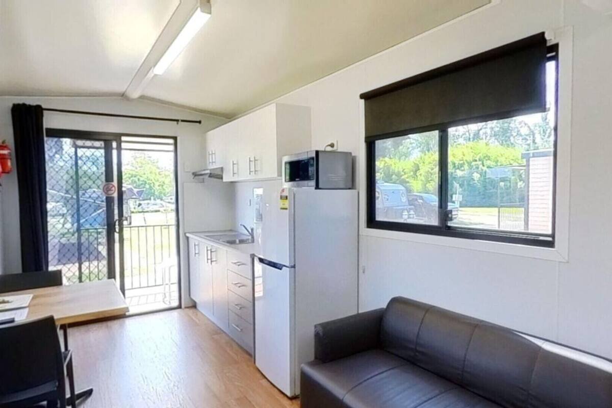 A compact living space with a kitchenette, a dining area, and a sofa.