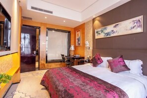 A modern hotel room with a large bed, a desk, and a chair. - Yilong International Hotel (Xincai Moon Bay Park) (Xincai)
