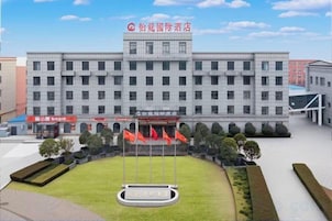 Un hotel con un patio central, varias banderas y un letrero con caracteres chinos.